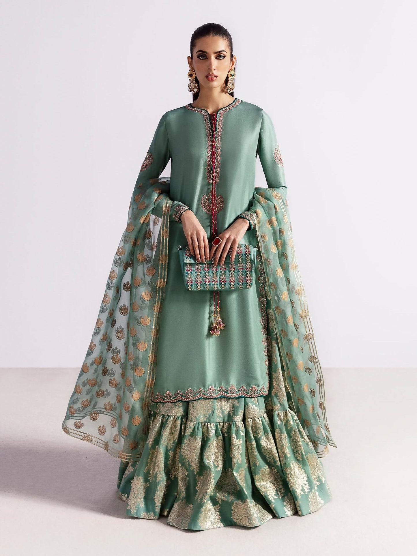 Hussain Rehar stitched 3-piece suit featuring an ice blue raw silk embellished shirt with sequins, naqshi, cutdana and dabka, paired with chanderi silk sharara with Thai silk lining and organza dupatta.