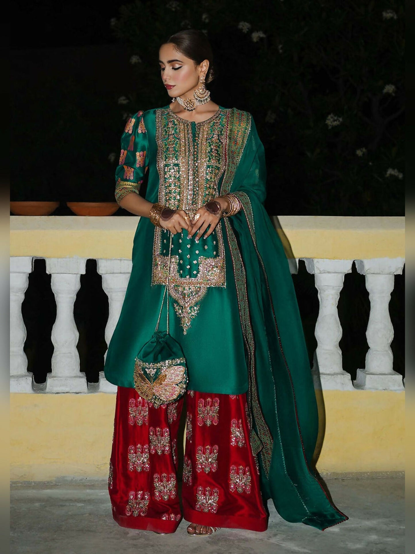 Stitched 3-piece suit by Hussain Rehar with green raw silk shirt featuring embellished neckline and block-printed puff sleeves, paired with red embellished shalwar and green organza dupatta with printed border