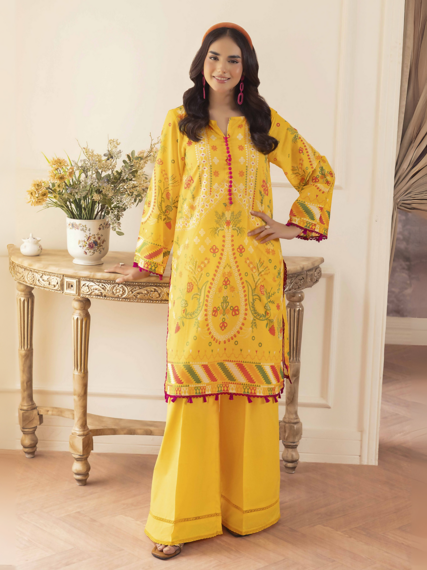Woman wearing a yellow unstitched 2 piece lawn suit with printed shirt and plain cotton trouser.