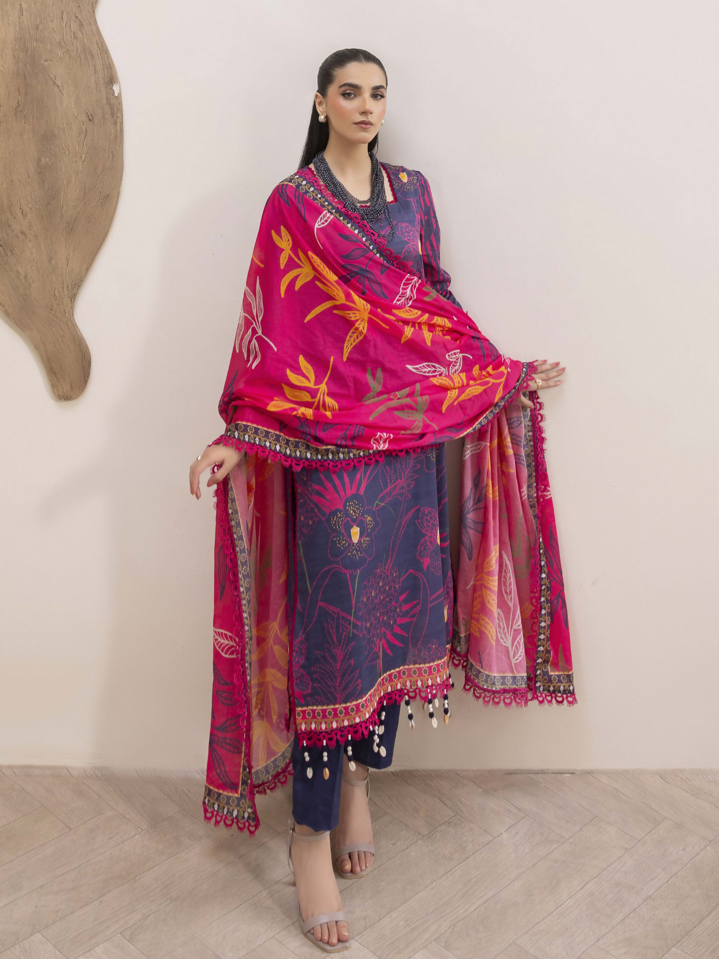 Girl standing wearing an unstitched 3-piece suit with premium digital printed slub lawn shirt, digital printed pure voile dupatta, and dyed cotton trouser, ideal for breathable and stylish summer wear.
