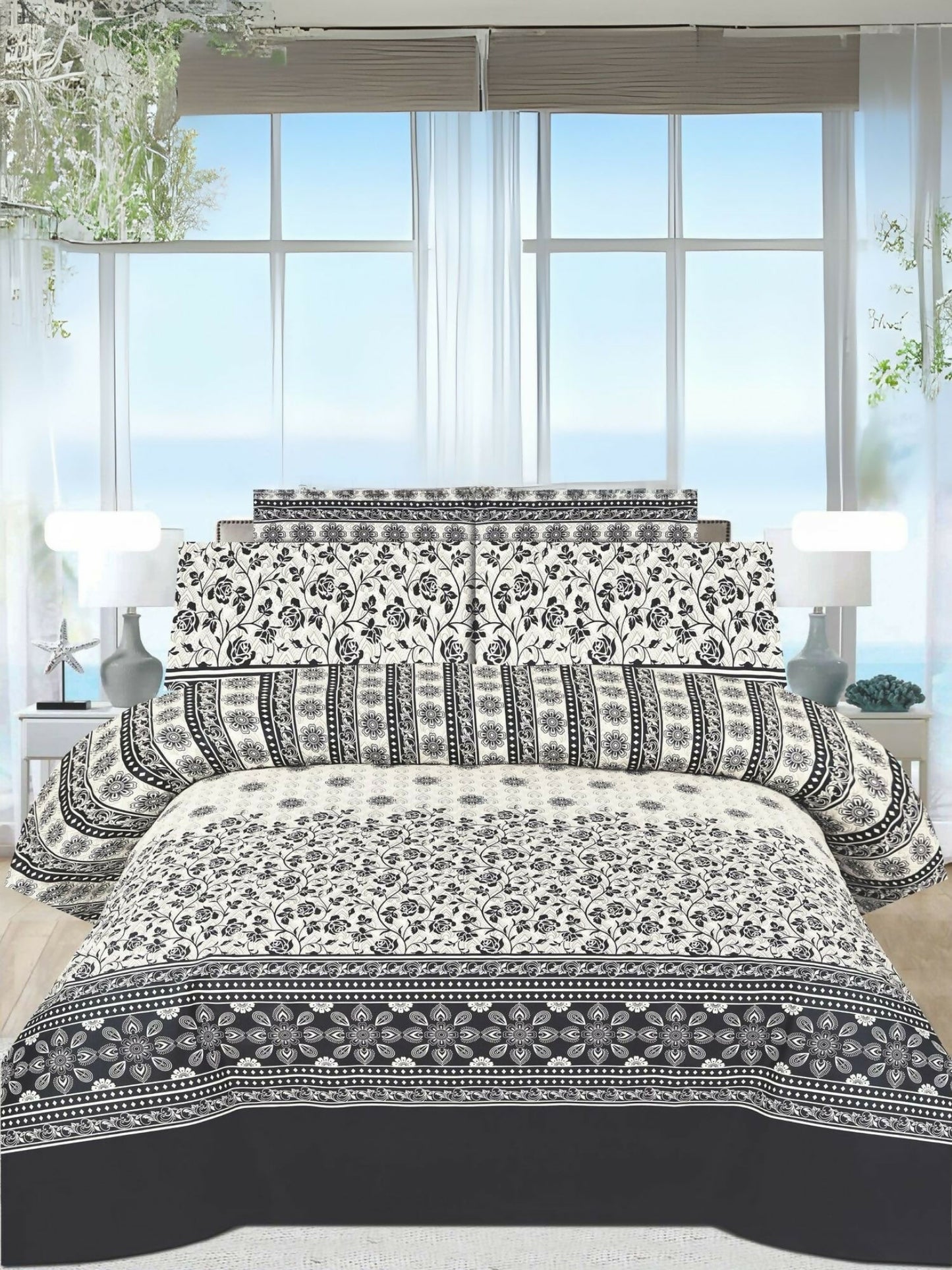 A white king-size bedsheet with a bold black floral design, paired with matching pillow covers, neatly spread on a bed.