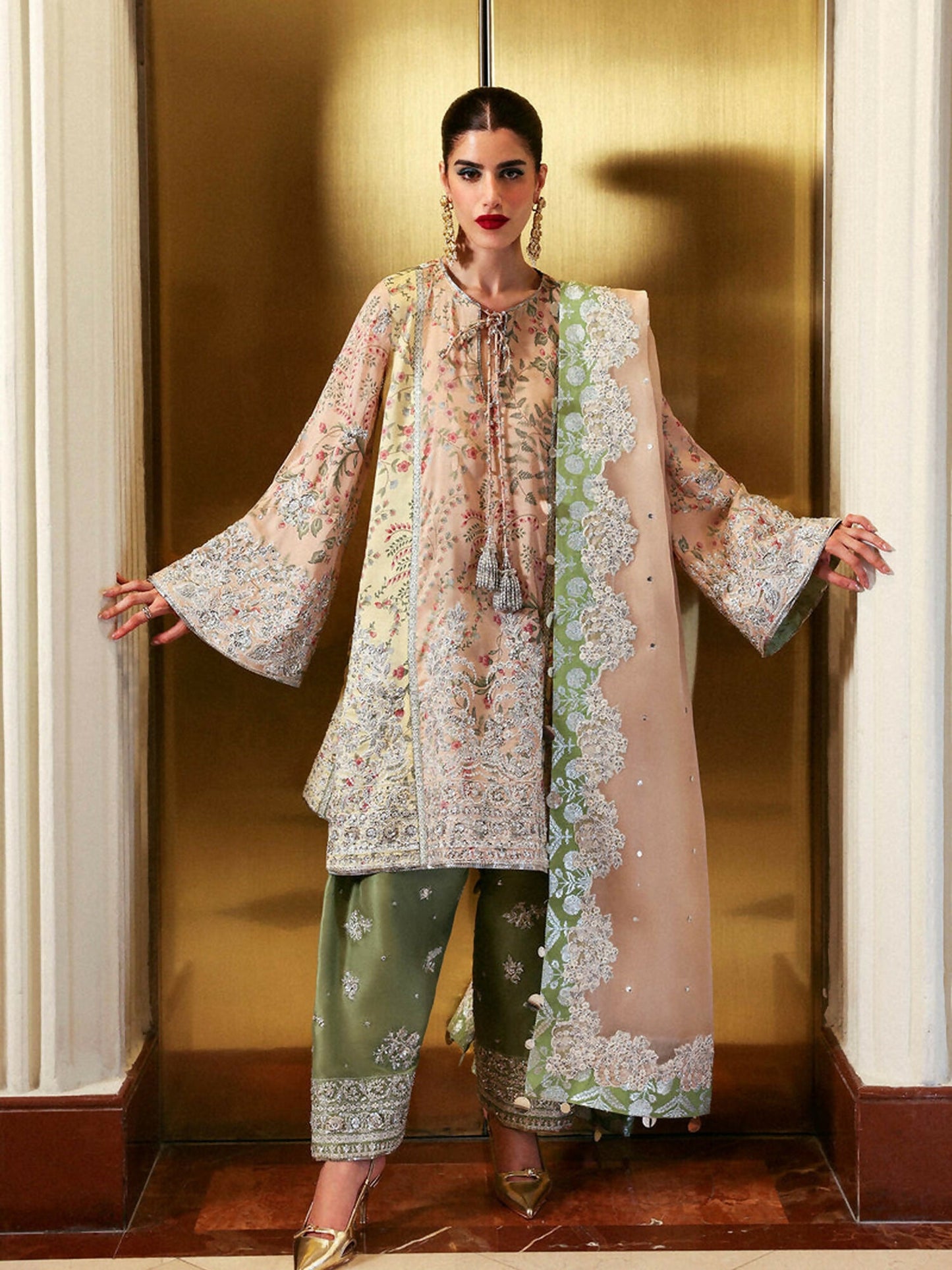 Hussain Rehar stitched 3-piece suit featuring tri-color raw silk paneled embroidered shirt with silver accents and tassels, peach organza dupatta with green chunderi silk facings, and olive green embroidered Pakistani shalwar.