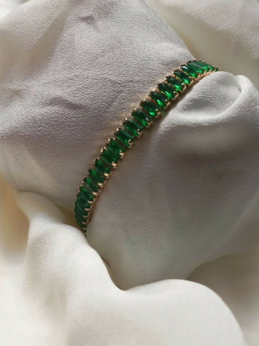 Joyels gold-toned bracelet with rich green stones, designed for luxe layering and timeless elegance.