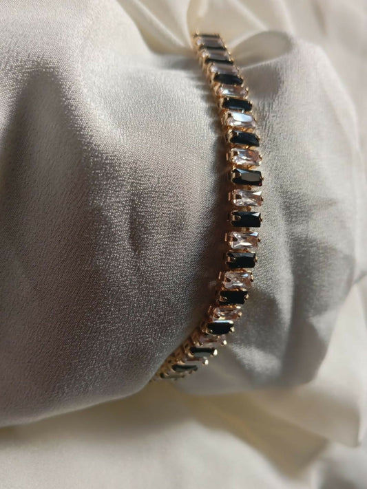 Joyels gold-toned bracelet with alternating deep blue and clear stones, crafted for elegance and sophistication.