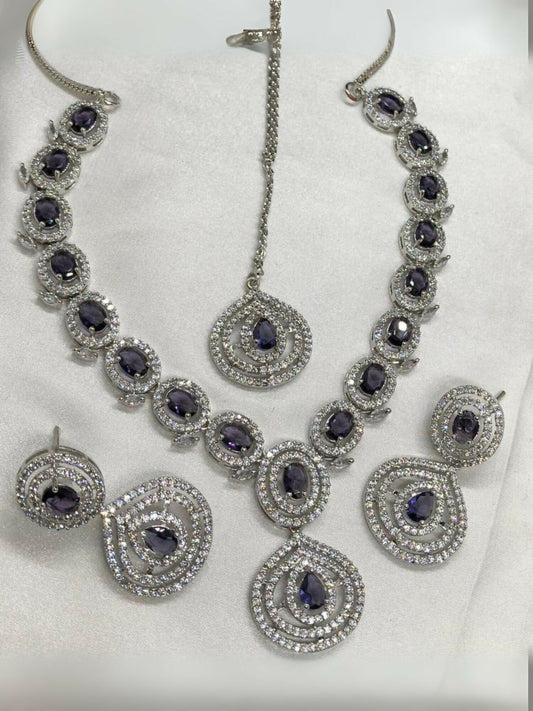 Noor Bilal one carat American diamond necklace set with matching earrings and bindi, featuring silver-toned stones and regal purple center stones.
