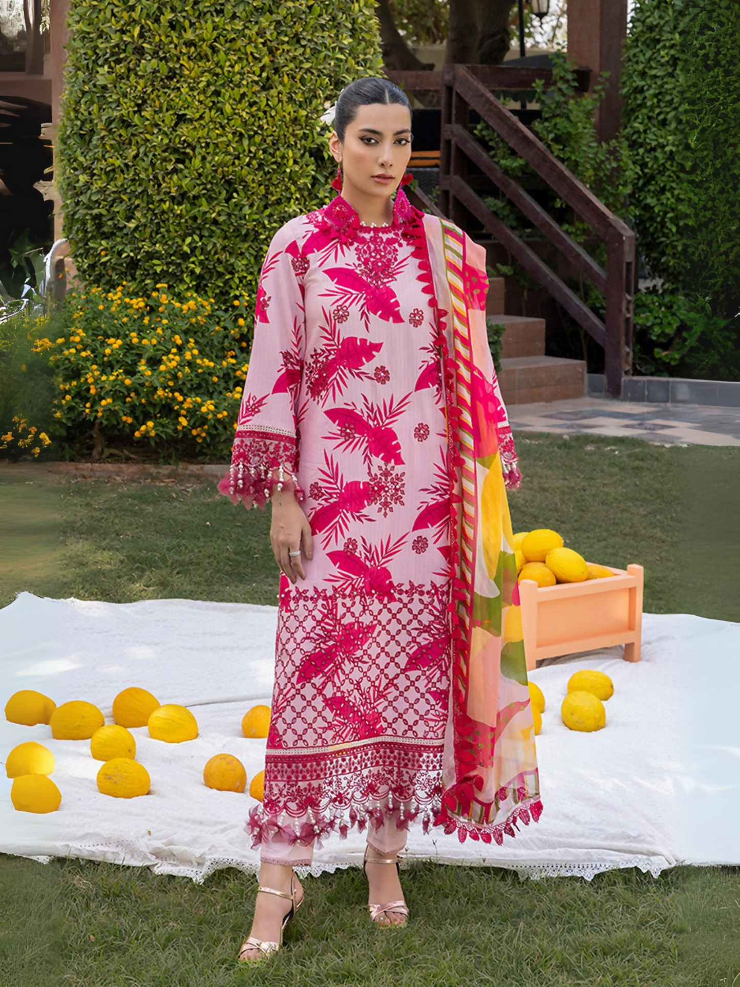 Woman wearing a light pink unstitched 3 piece suit with dark pink chikankari leaf embroidery, chiffon dupatta, and cotton trouser.