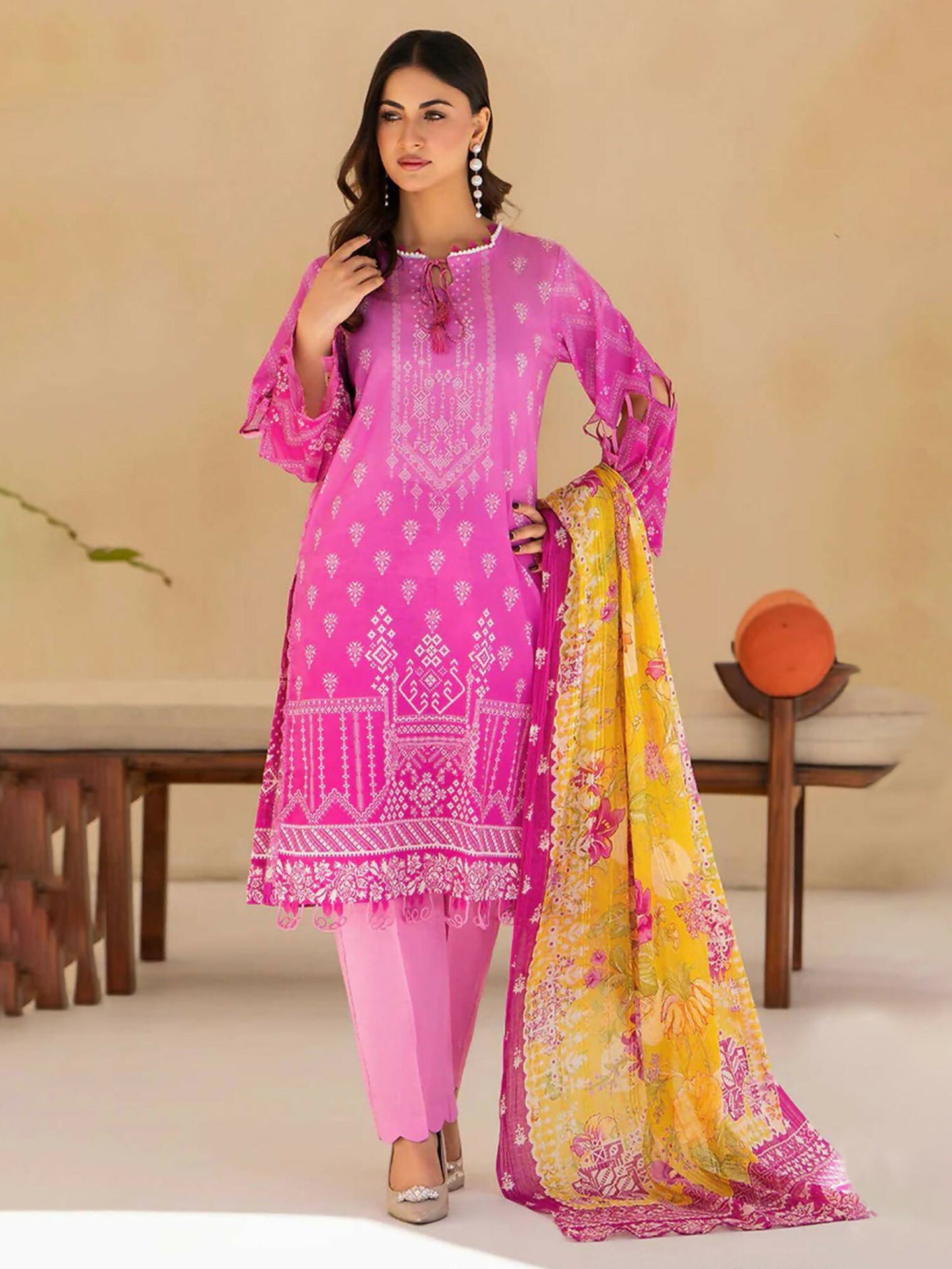 Unstitched 3-piece suit featuring pink digital printed slub lawn shirt with white tribal motifs and border accents, yellow fancy fabric dupatta with pink floral designs, and plain pink lawn trouser.