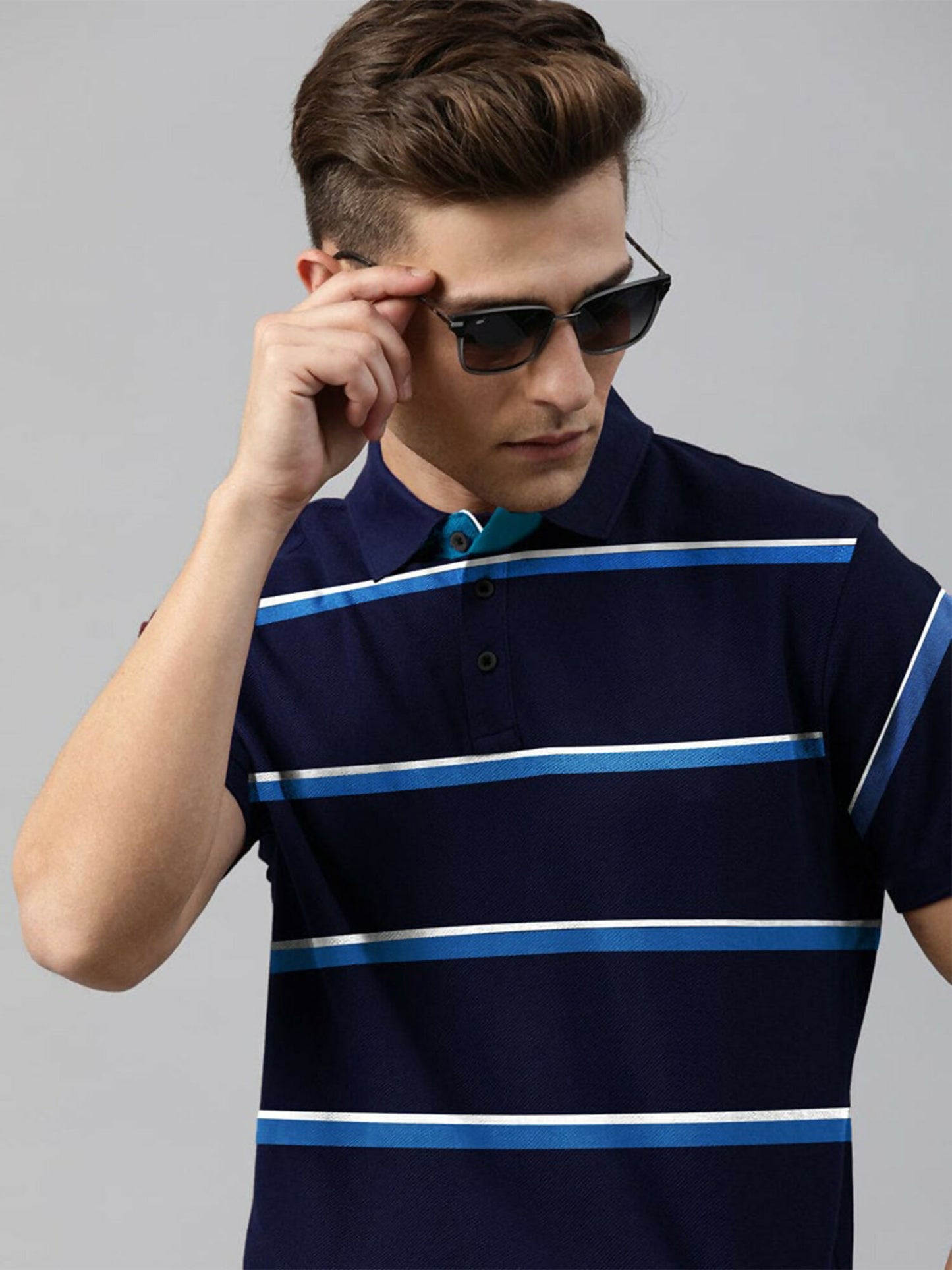 A man wearing a striped cotton jersey polo in a slim fit, featuring a tailored collar and a soft, comfortable texture.