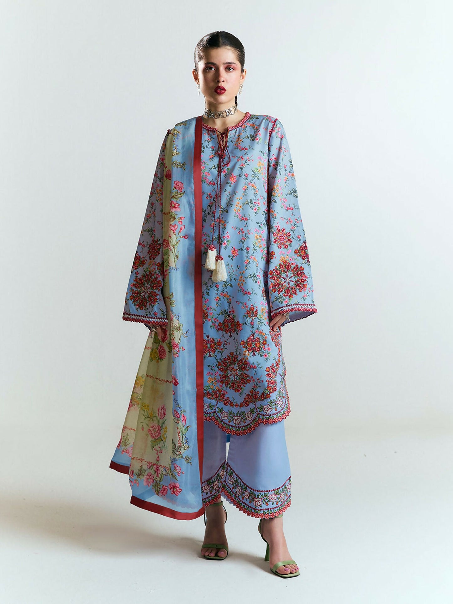 Light blue printed cotton shirt with multicolor floral embroidery, scalloped borders, and tassel ties, paired with matching embroidered culottes and a digitally printed silk dupatta in soft floral hues.
