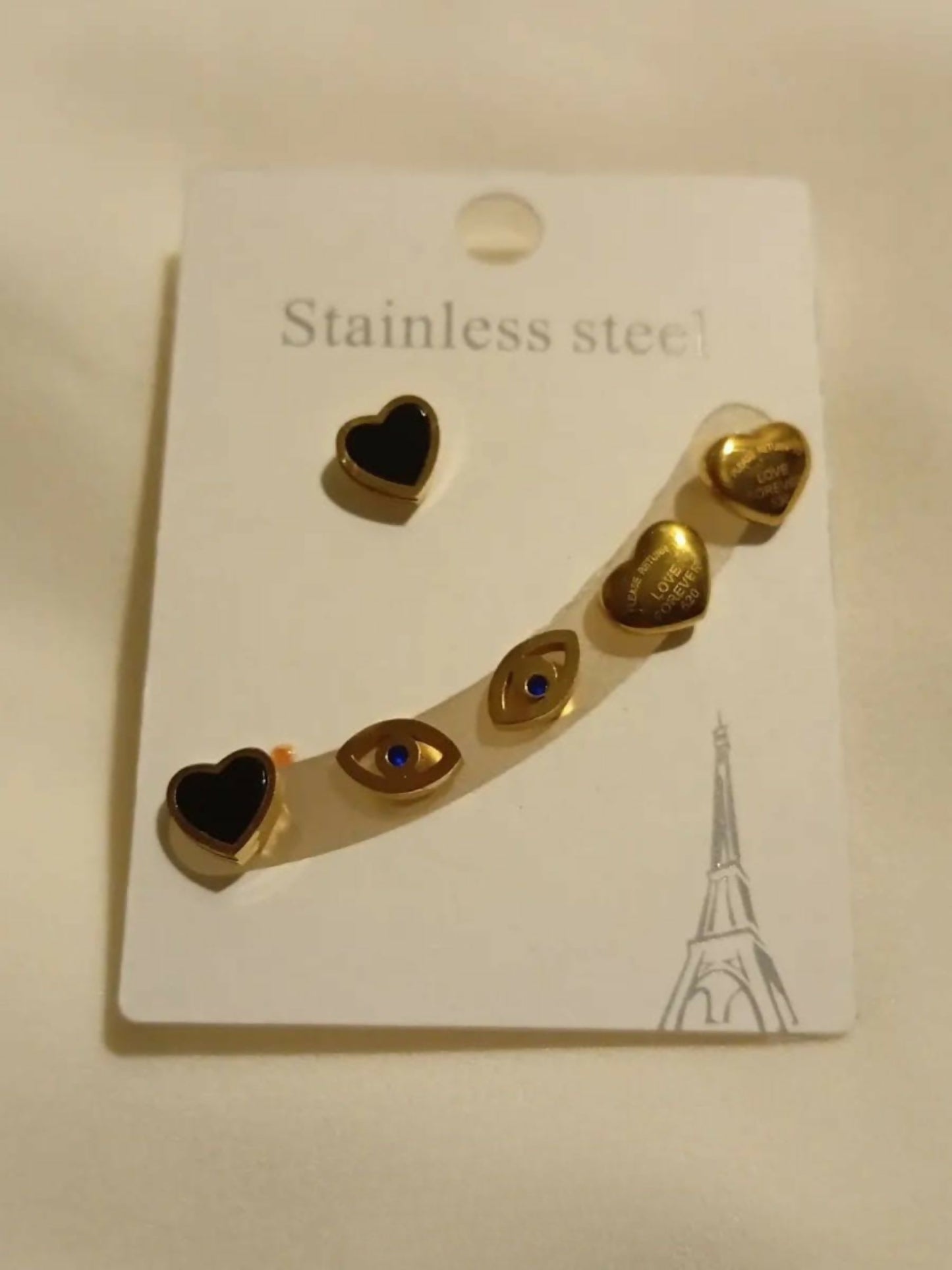 Joyels stainless steel earcuff set featuring hearts, evil eyes, and golden love notes, designed to add chic Parisian charm to any look.