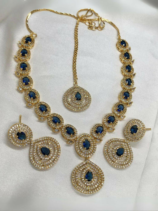 Noor Bilal one carat American diamond necklace set with matching earrings and bindi, featuring silver-toned stones, gold accents, and navy blue center stones.