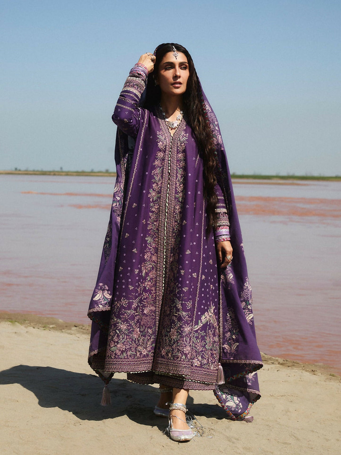 Deep purple embroidered lawn shirt with intricate patterns on bodice and sleeves, matching cotton trousers, and printed lawn dupatta for a coordinated festive look.
