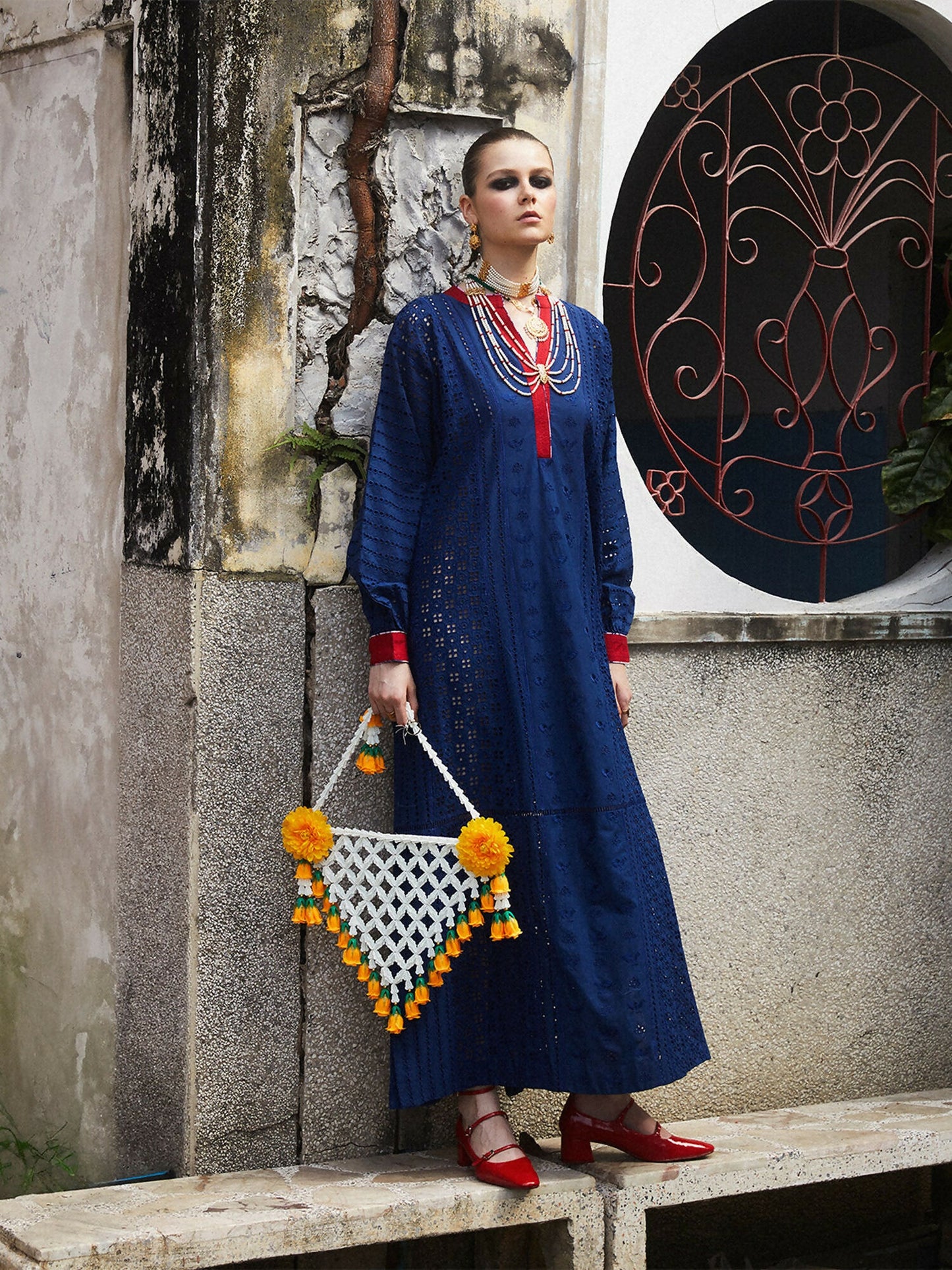 Woman wearing cotton long straight shirt with shiffli embroidery, slide slits, and red detailing on sleeves and neckline, 1-piece unstitched shirt.