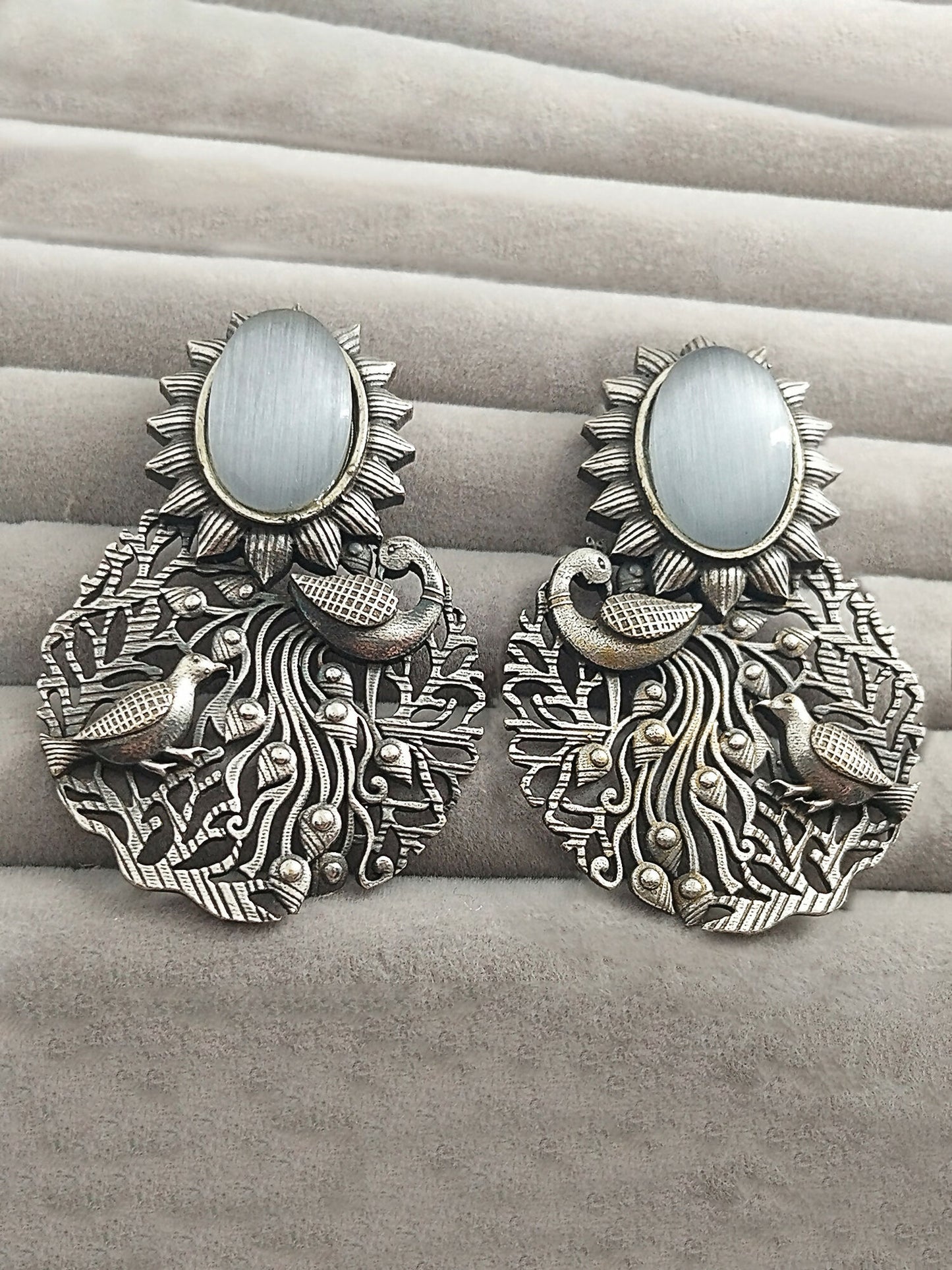 H&A Jewellery silver peacock motif earrings with white stone and sunburst design