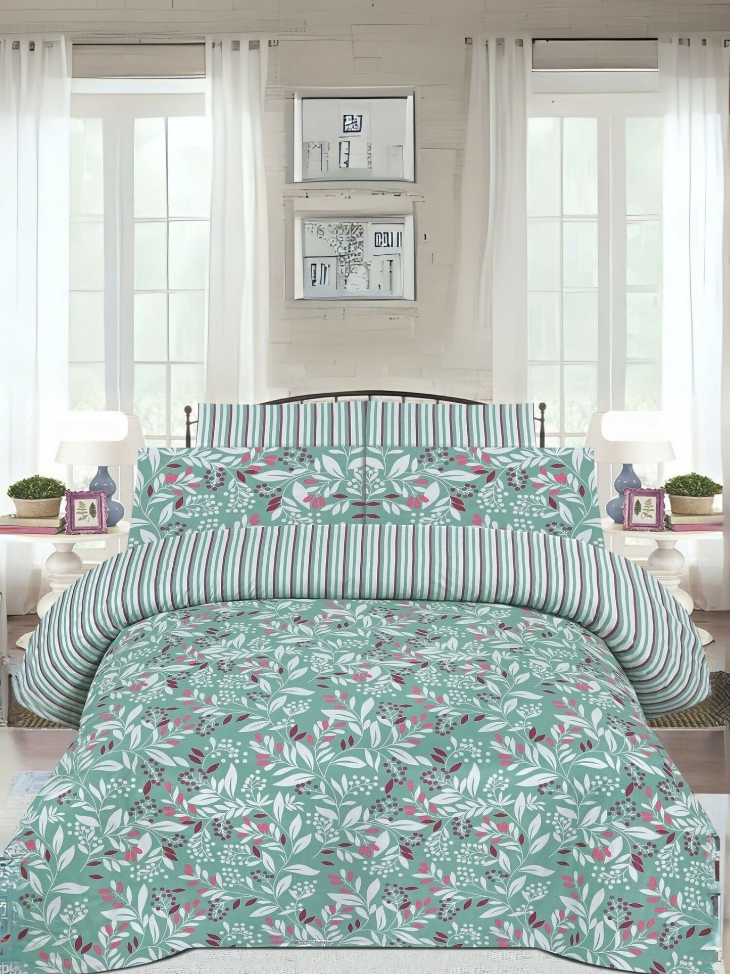 A mint green king size bedsheet with leafy print, laid out on a bed with matching pillow covers.