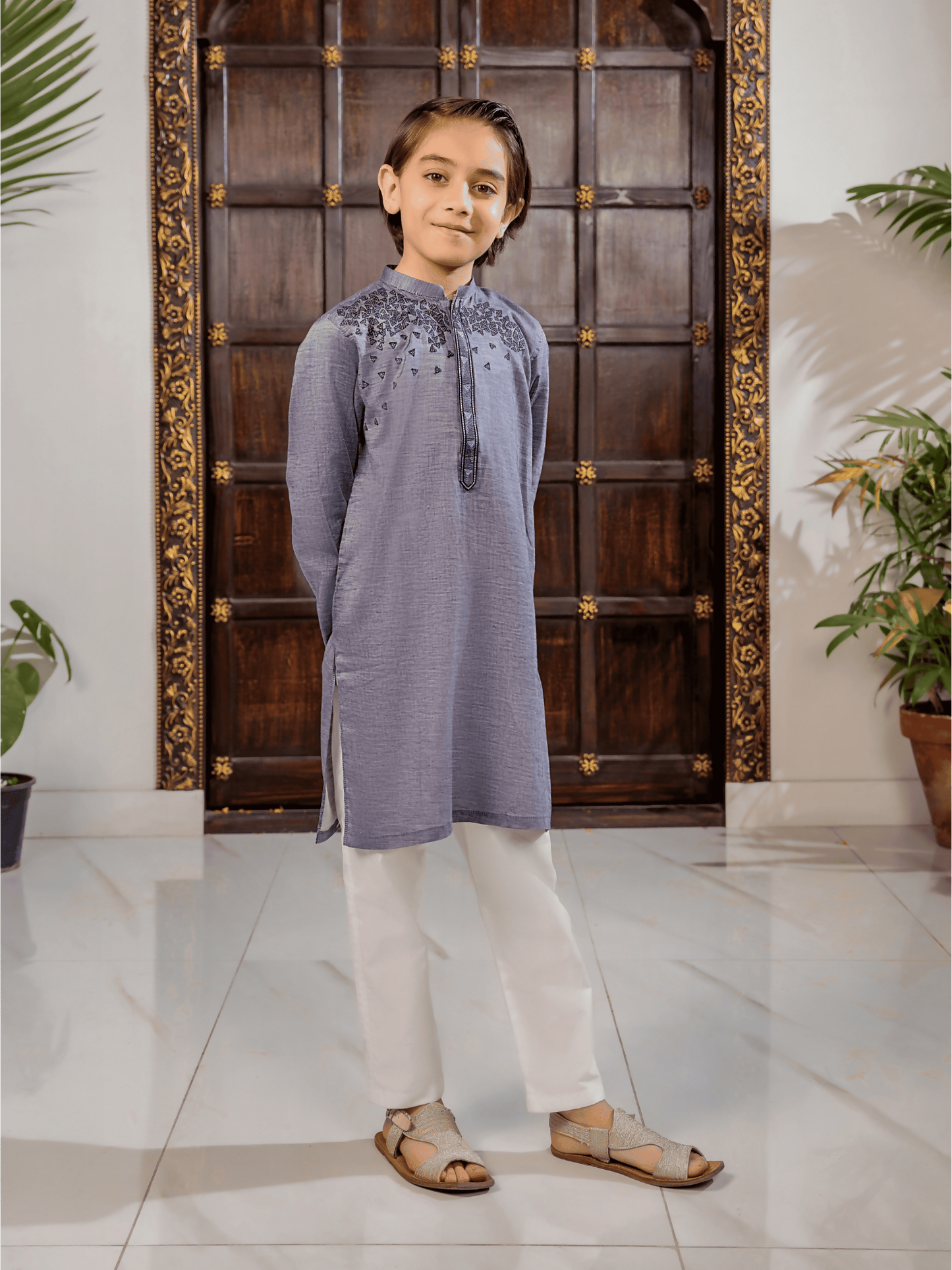 Boy wearing cotton stitched kurta featuring a mandarin collar, full sleeves, regular fit, and refined front embroidery – ethnic wear outfit for kids.
