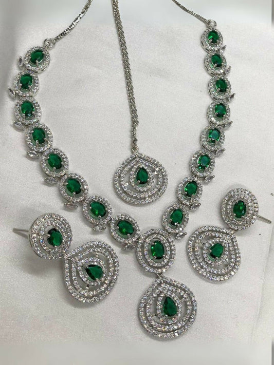 Noor Bilal one carat American diamond necklace set with matching earrings and bindi, featuring silver-toned stones and striking green center stones.