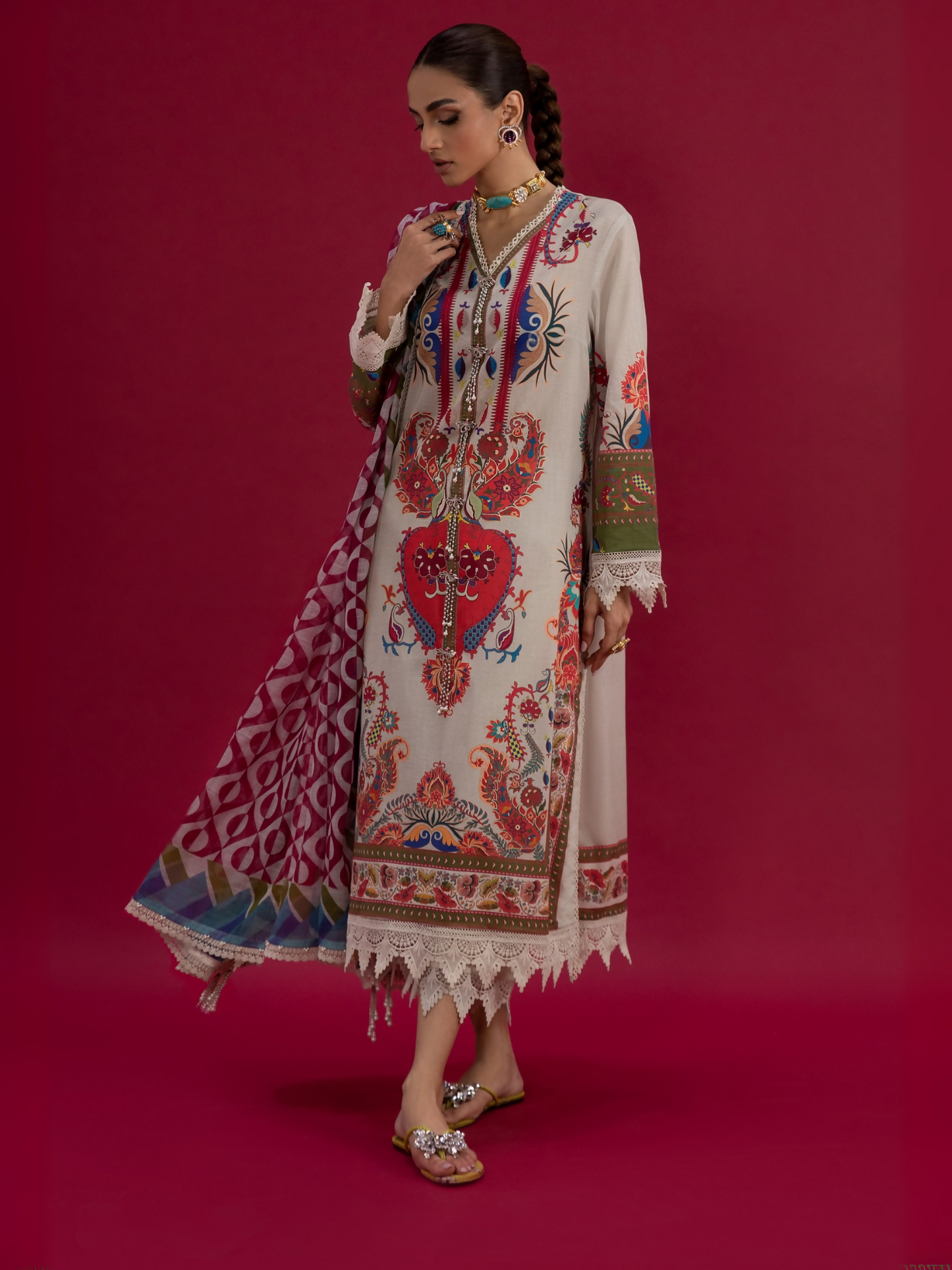 Woman wearing a nude unstitched 3-piece suit with multicolor printed design, paired with a matching printed dupatta and dyed cambric trouser.