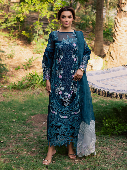 Girl standing wearing an unstitched 3-piece suit with embroidered lawn shirt featuring center organza panel, embroidered sleeves, neckline, and daman, paired with an embroidered Monark dupatta and dyed Cambridge trouser with slip, perfect for formal occasions.