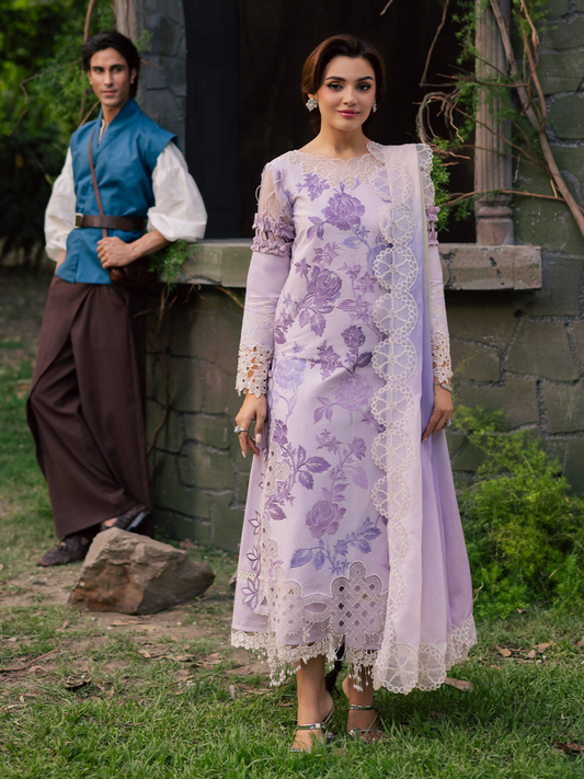 Girl standing wearing an unstitched 3-piece suit with embroidered lawn shirt front, neckline, patch and daman, paired with a printed embroidery voil dupatta and dyed Cambridge trouser, suitable for festive and elegant daywear.