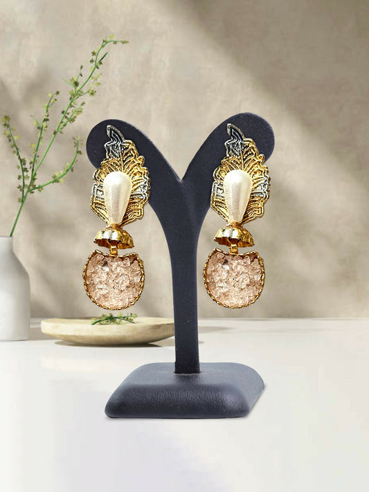 Glitter Jewellery gold-toned statement earrings featuring pearl accents, leaf motifs, and textured round drops, displayed on a black stand.