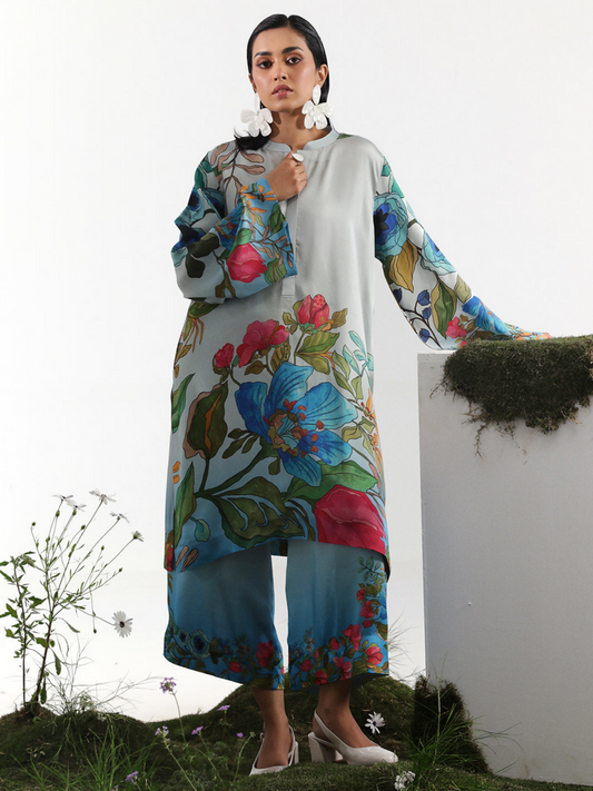 Model wearing a powder blue digital printed silk co-ord set with vibrant oversized floral patterns and full-length sleeves
