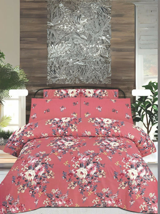 A coral-pink king size bedsheet set with vintage-style floral clusters, paired with matching pillow covers, displayed neatly on a bed.