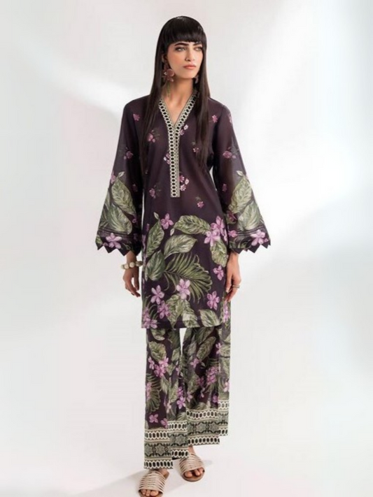 Model showcasing a vibrant deep plum lawn suit adorned with delicate lilac flowers and green foliage prints, paired with matching printed pants from Parizad Premium Lawn Collection.