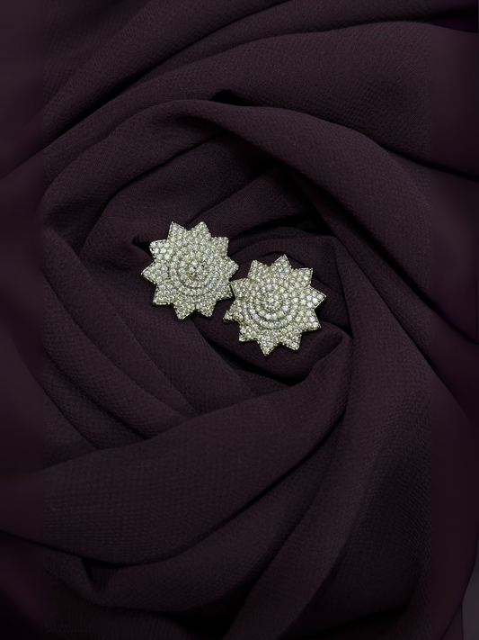 Floral crystal stud earrings with clear stones in a silver finish, arranged in a layered petal design.