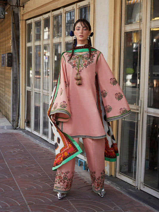 Woman wearing peach pink embroidered cotton straight shirt with flared sleeves, matching embroidered cotton plazzo pants, and printed silk dupatta, 3-piece unstitched suit.