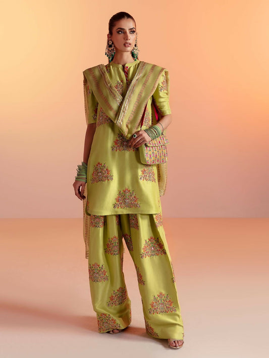 Hussain Rehar stitched 3-piece suit featuring a banana green raw silk embellished shirt with gold sequins, naqshi and cutdana, paired with raw silk multi-head palazzo pants and organza dupatta.
