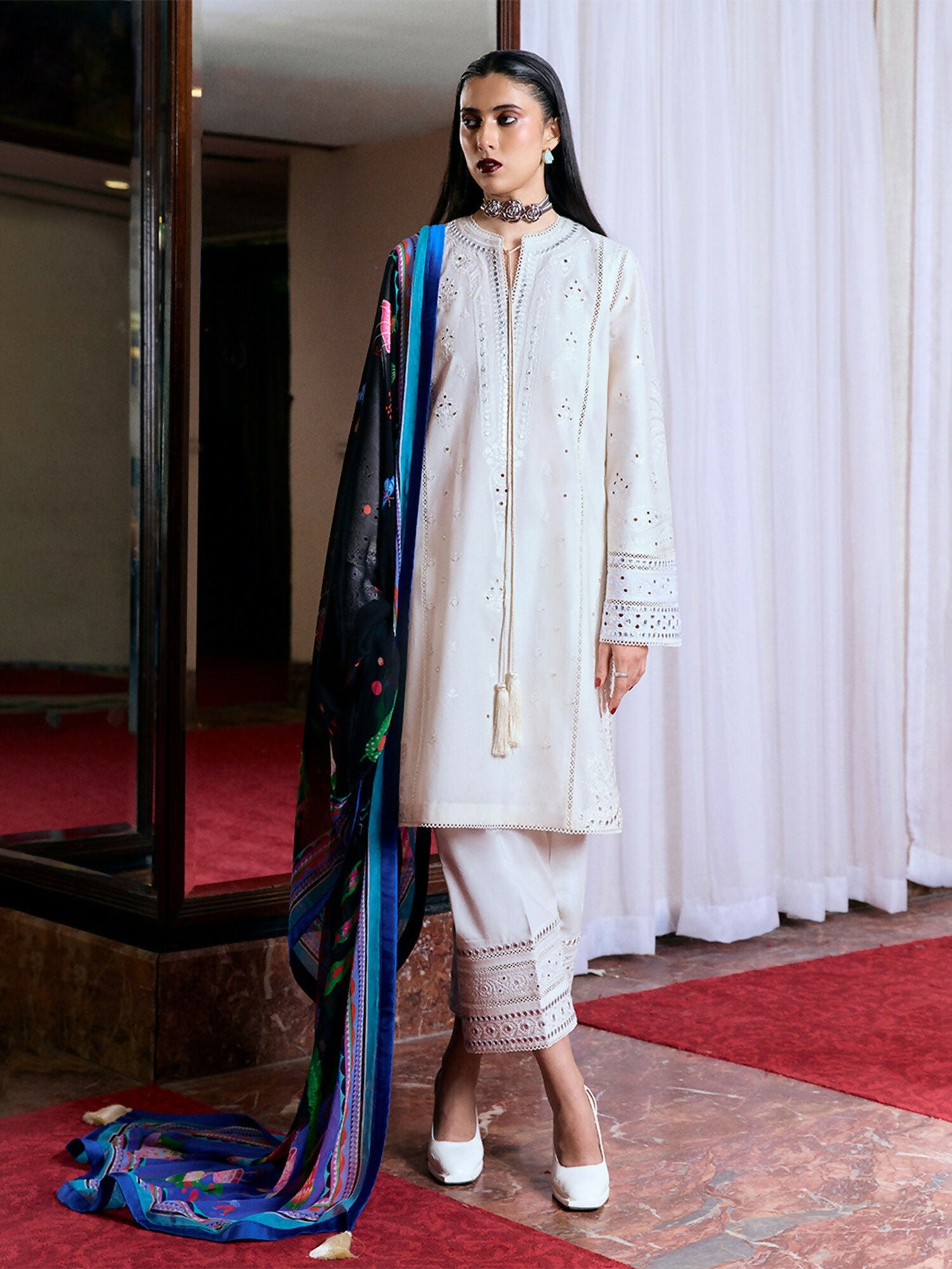 Off-white cotton long shirt with monochrome embroidery, panni work, boring, and tassels, bell sleeves with matching embellishments, culottes with similar embroidery, and digitally printed chiffon dupatta.