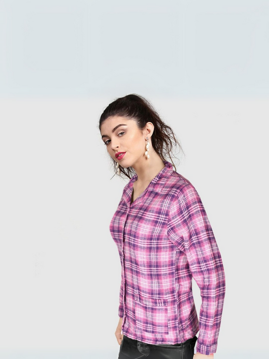 A woman wearing a long-sleeved pink and purple plaid flannel shirt with a coat collar, styled casually with black jeans.