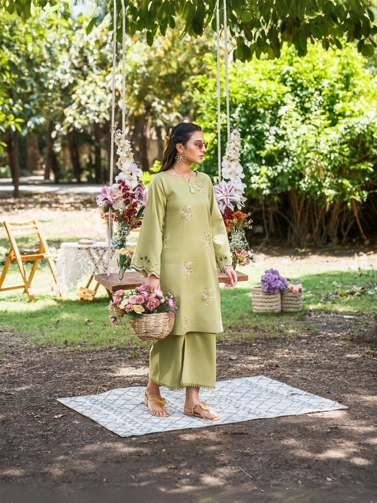 Moss green stitched two-piece suit with embroidered front and sleeves, cutwork and scallop detailing, paired with culottes trousers with lace trim by Sehrish Kanwal.
