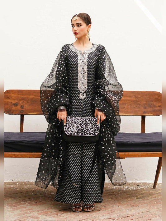 Hussain Rehar stitched 3-piece suit featuring a raw silk screen printed shirt with embellished neckline, Indian raw silk screen printed chooridar, and organza dupatta with silver spray.
