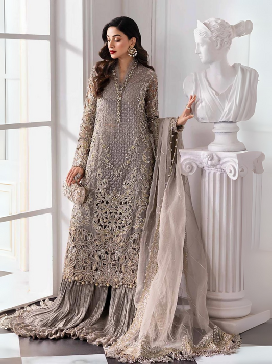 Woman wearing a luxury 3-piece organza suit with an embroidered shirt, raw silk trouser, and embellished organza dupatta