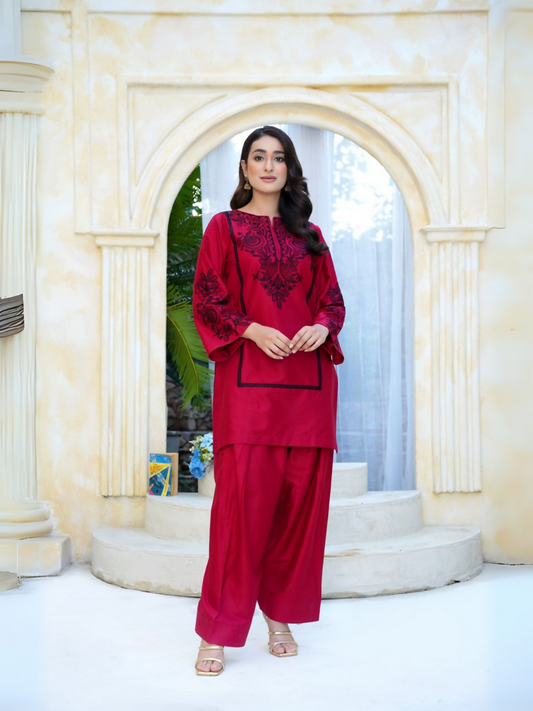 Girl wearing Trends Forever cherry red lawn cotton embroidered kurta with black motifs, flared sleeves, and matching shalwar; stitched 2-piece suit.
