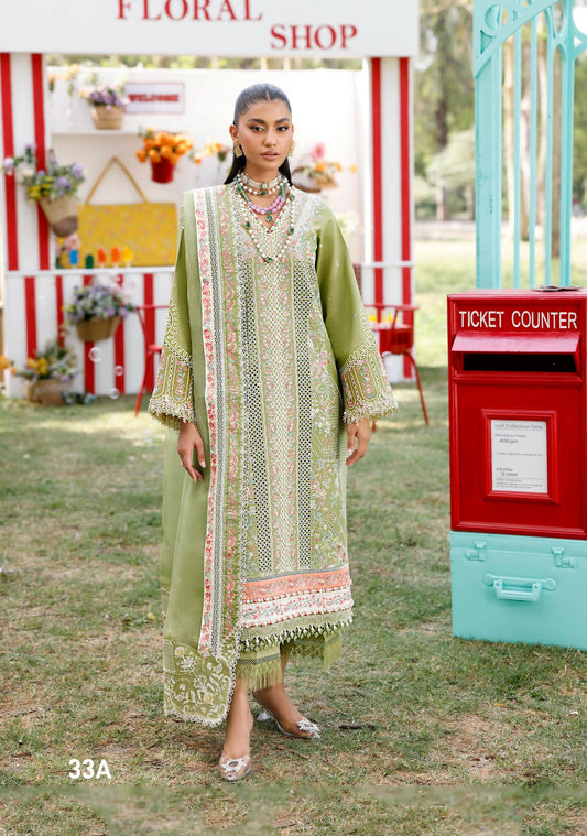 Girl standing wearing unstitched embroidered lawn suit with embroidery on front left and right, organza sleeve motifs, layered daman laces in silk and organza, chiffon dupatta with embroidered pallos and dual-side laces, paired with dyed cotton trouser