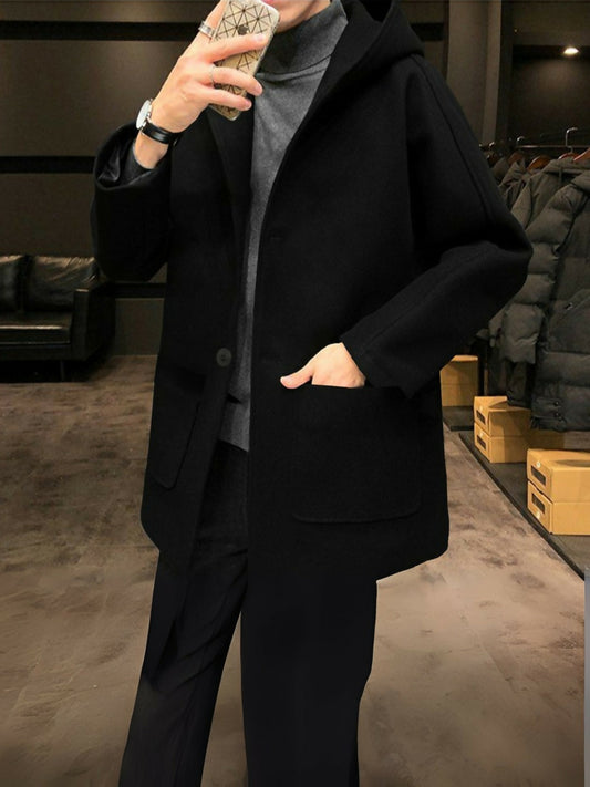 Man wearing a funky hooded woolen black long coat with full-length design and sleek silhouette, perfect for winter wear