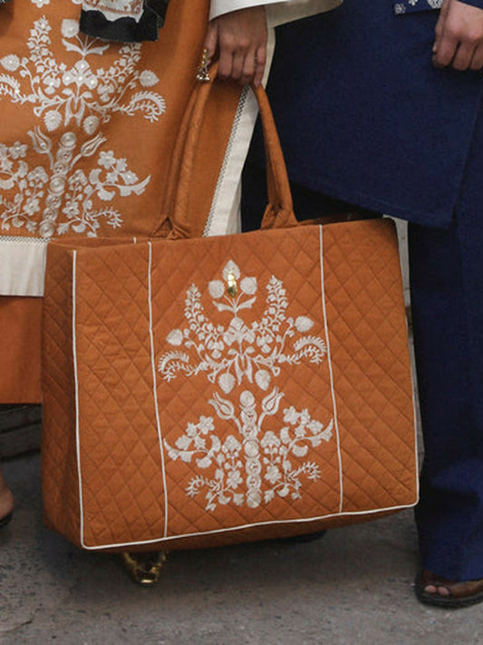 Emblem Quilted brown tote bag with ivory motif, spacious interior, and sturdy handles, elegant bold accessory for office, travel, or casual wear.