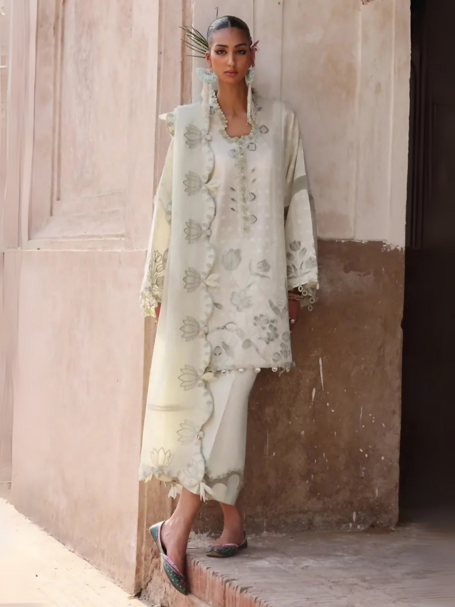 Unstitched 3-piece suit by Elan with embroidered self-jacquard appliqué shirt, voile dupatta with lotus appliqués, and dyed cambric trouser.