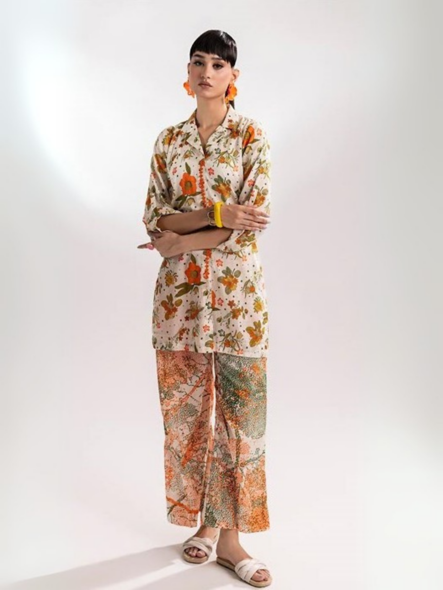 Woman wearing a beige floral printed shirt with matching abstract multicolor printed trousers from Parizad's unstitched lawn collection.