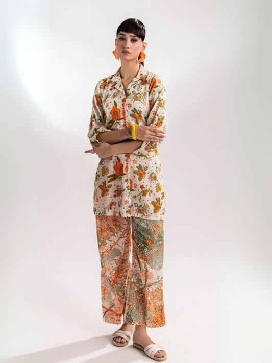 Woman wearing a beige floral printed shirt with matching abstract multicolor printed trousers from Parizad's unstitched lawn collection.