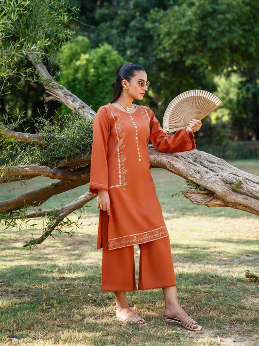 Rust stitched two-piece suit with embroidered front and sleeves, running stitch details on sleeves, paired with culotte trousers by Sehrish Kanwal.