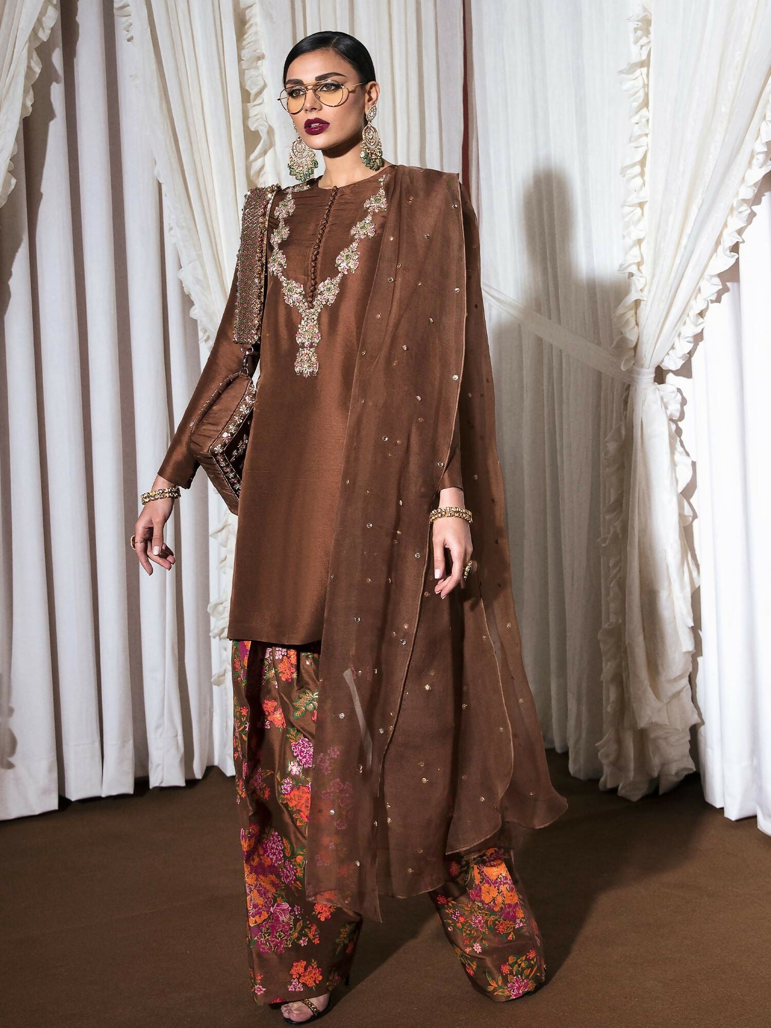 Brown raw silk stitched 3-piece suit Sorel by HussainRehar featuring an embellished shirt with nakshi, dabka, sequins, mukaish, multicolor bugle beads, and loop buttons, paired with a printed raw silk shalwar and an organza dupatta sprayed with gold sequins