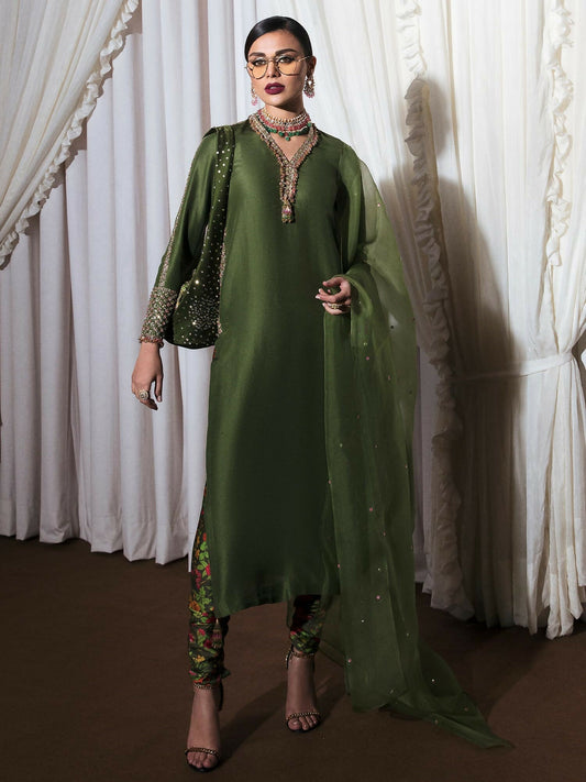 Green raw silk stitched 3-piece suit Zelen by HussainRehar featuring an embellished shirt with sequins, bugle beads, nakshi, and resham embroidery with tassel detail and hand-worked pockets, paired with a printed satin chooridar and an organza dupatta sprayed with gold and pink sequins