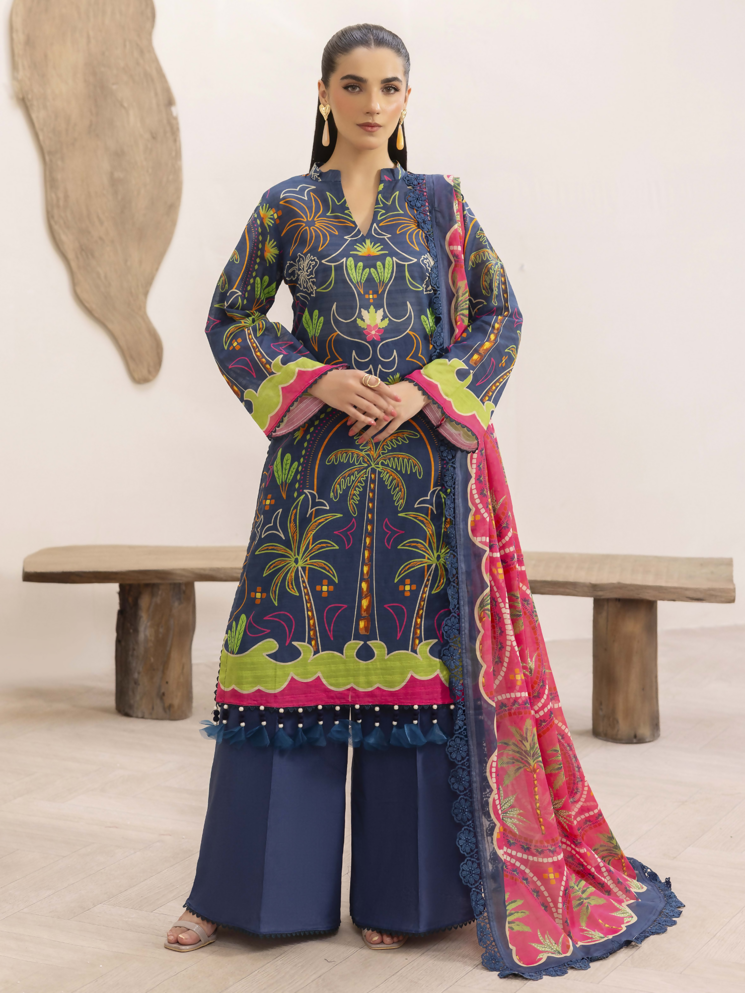 Girl standing wearing an unstitched 3-piece suit with premium digital printed slub lawn shirt, digital printed pure voile dupatta, and dyed cotton trouser, ideal for breathable and elegant summer wear