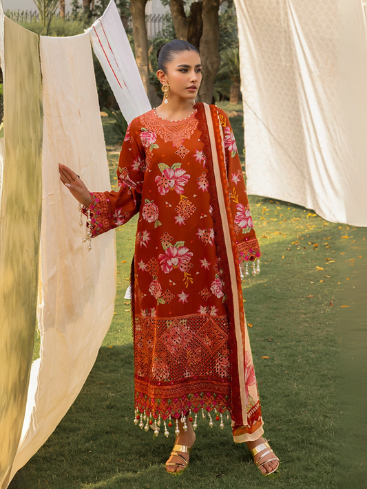 Woman wearing a reddish-orange unstitched 3 piece suit with pink chikankari floral embroidery, chiffon dupatta, and cotton trouser.