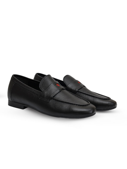 Black leather loafers with a sleek profile and subtle shine, combining modern edge with lasting comfort.