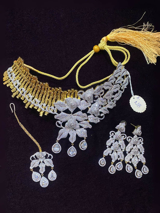 Noor Bilal one carat zircon stone bridal set with heavy dual-tone gold and silver necklace, floral motifs on silver side, earrings, and bindi.